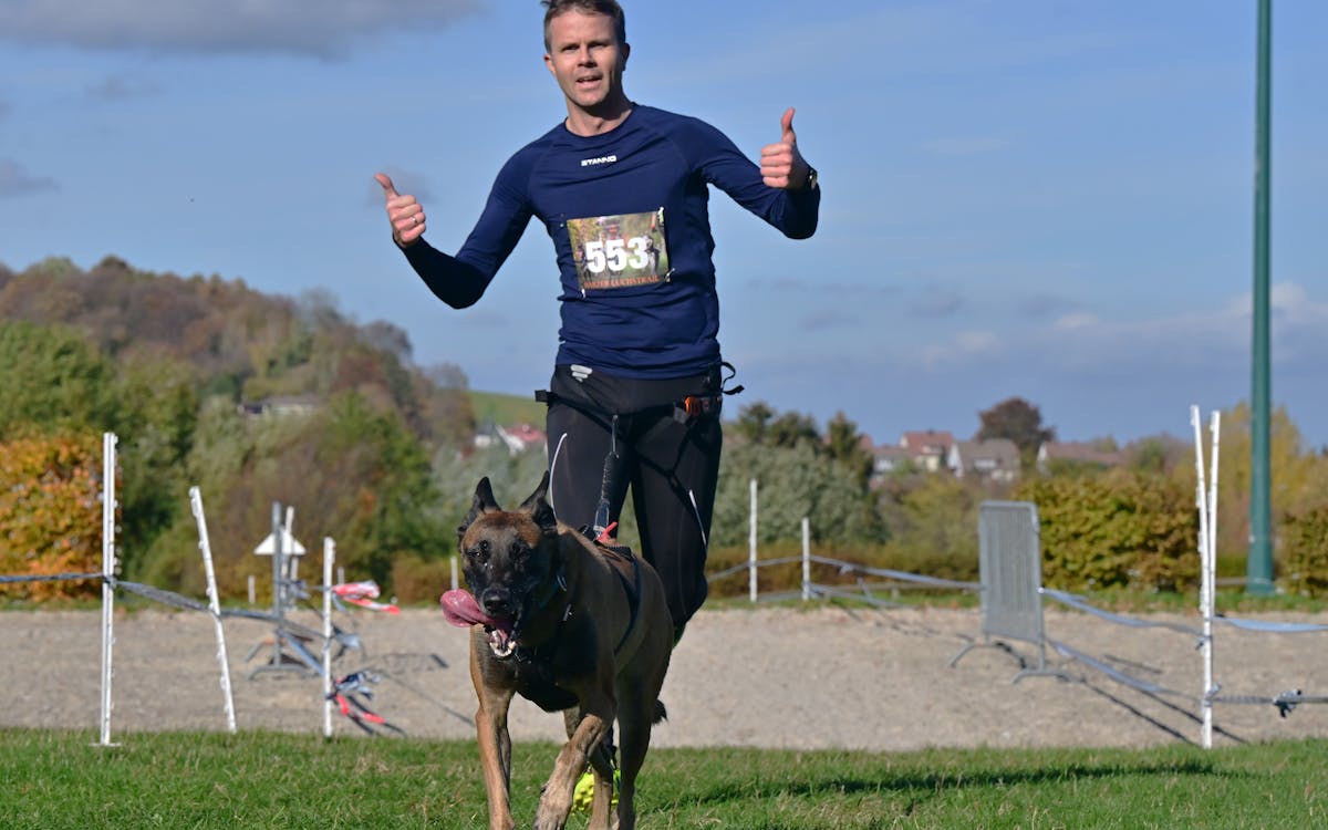 Persona corriendo con su perro en competencia de canicross